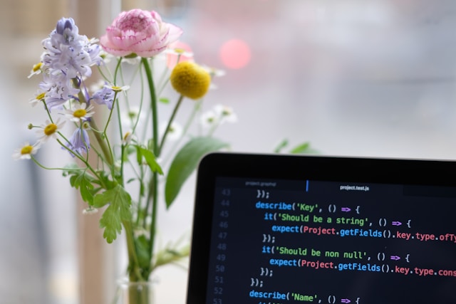 flowers next to laptop with code